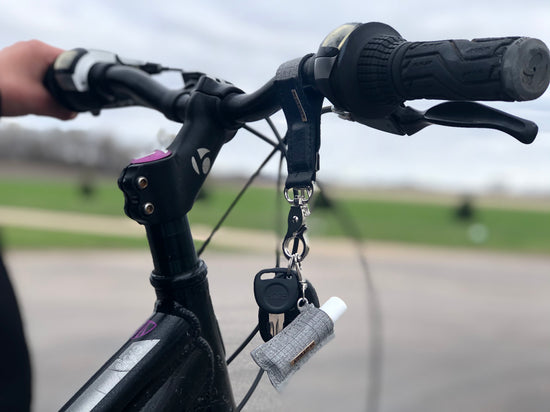 A bracelet keychain with lip balm holder and keys attached to a bicycle.it 