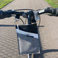 A black and gray vegan leather phone pouch with a black vegan leather magnetic wristlet key chain and a black and gray removable three pocket wallet used as a bike bag.